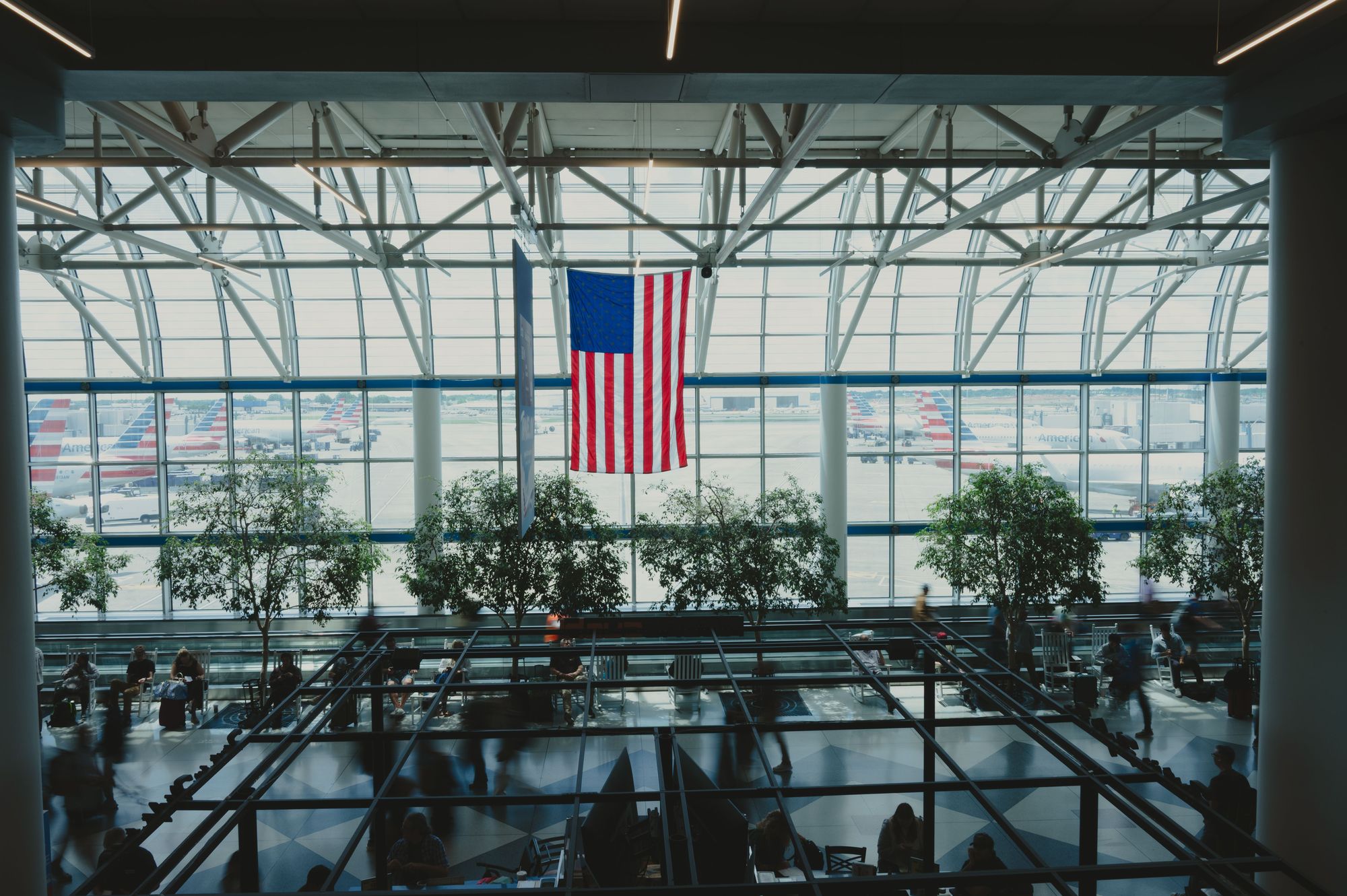 Inside a bright airport terminal with tall glass walls