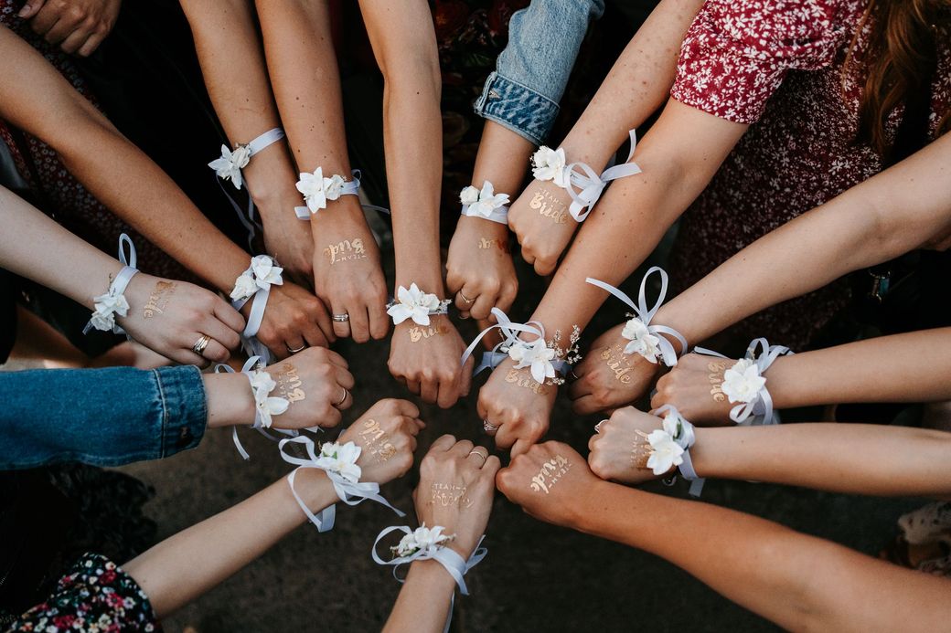 Friends with matching ribbon bracelets joining hands in a circle