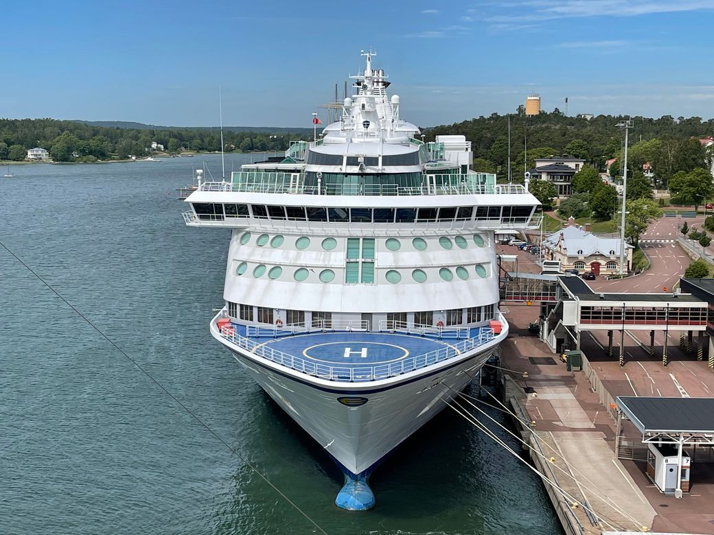 A large cruise ship docked at the pier on a clear day