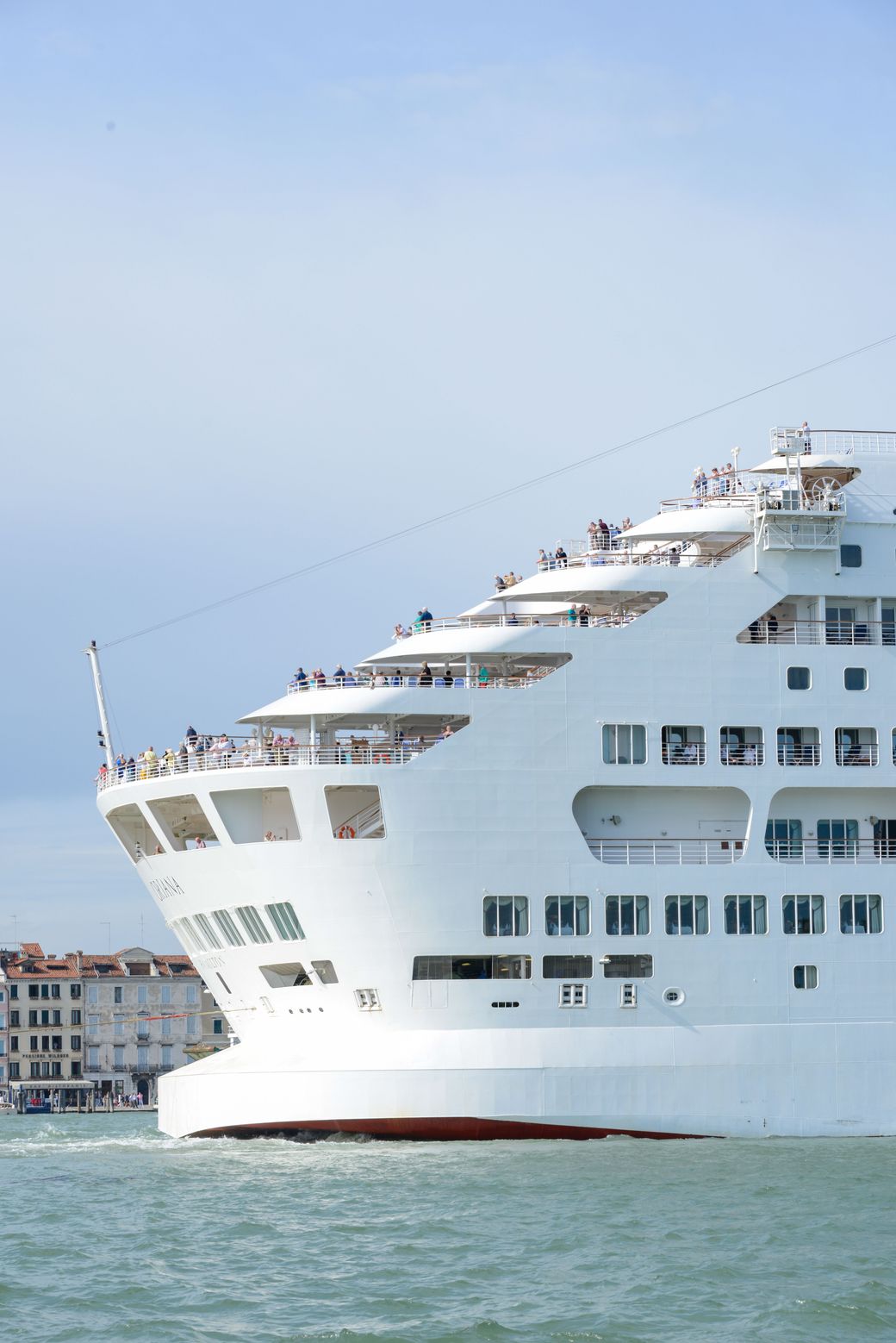 A large cruise ship docked in port, seen from the bow