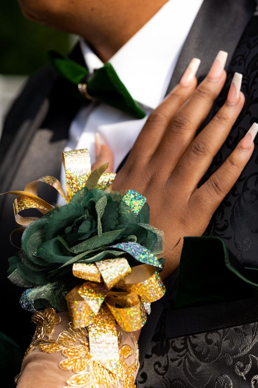 A wrist corsage on a hand resting on a dark suit
