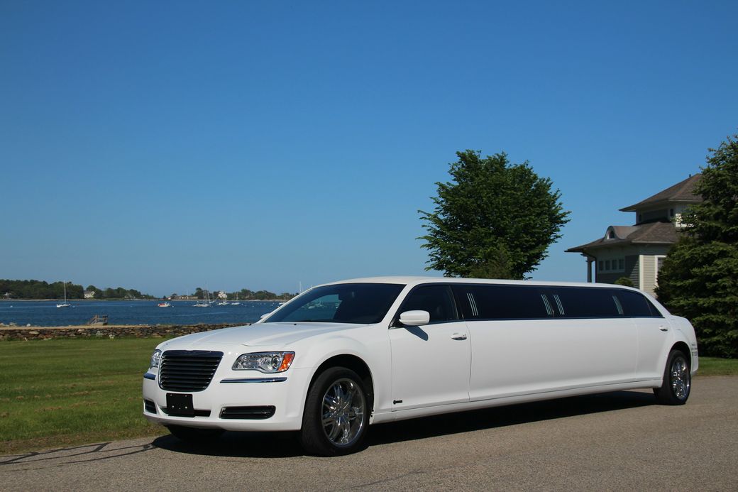 A white stretch limousine parked on a waterfront drive